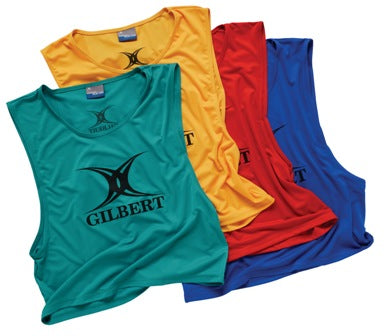 A sleeveless, lightweight polyester Gilbert Rugby Training Bib in amber features the Gilbert logo in black, ideal for rugby training. The pinnie is arranged overlapping with others for display.