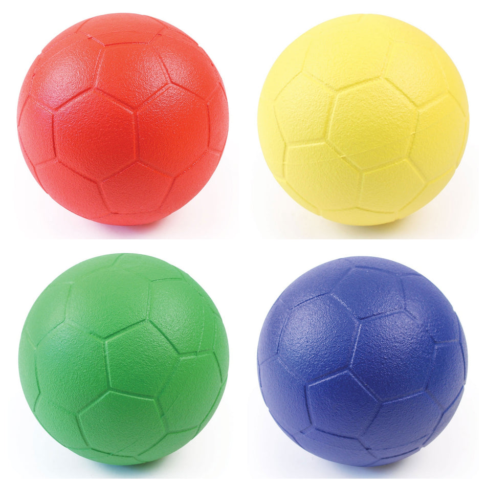 Four Martin Berrill Sports Coated Foam 32 Panel Footballs arranged in a square: red top left, yellow top right, green bottom left, blue bottom right. Each features visible hexagonal patterns and is designed for indoor or outdoor play.