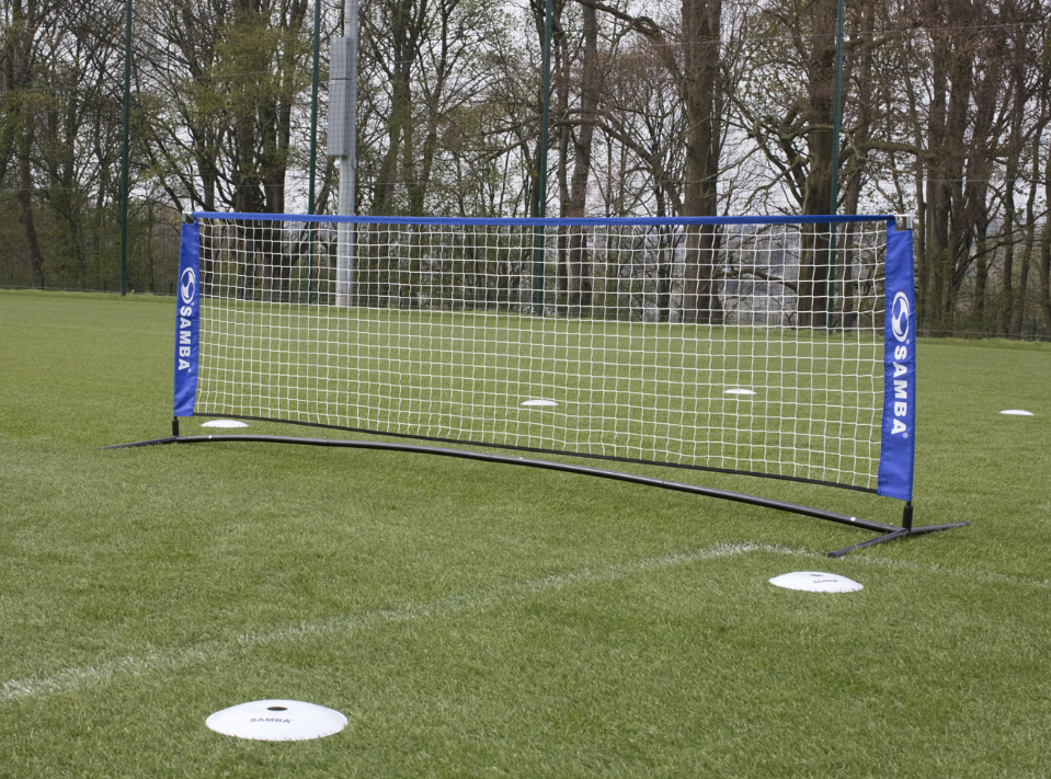 The Samba Head Tennis Skills Set by Samba Sports is set up on grass with white marker discs, perfect for header and volley training. Trees and a fence can be seen in the background.