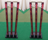 Two sets of maroon Gray Nicolls Custom Printed Match Cricket Stumps with Heavy Rubber Base, featuring "THE CRYPT SCHOOL" in yellow, stand on green artificial turf inside an indoor practice net.