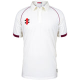 The Martin Berrill Sports Eastcombe CC Matrix V2 Short Sleeve Match Shirt is white with maroon trim on the sleeves and shoulders, featuring a collar, buttoned placket, and a small red and black logo on the left chest.
