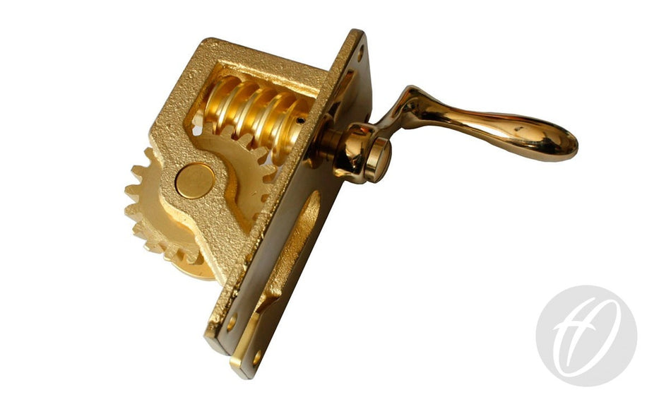 A shiny brass Winder For 76MM Tennis Posts by Harrod Sport, featuring a lever handle and gears, is shown on a white background with a faint circular logo in the bottom right corner.