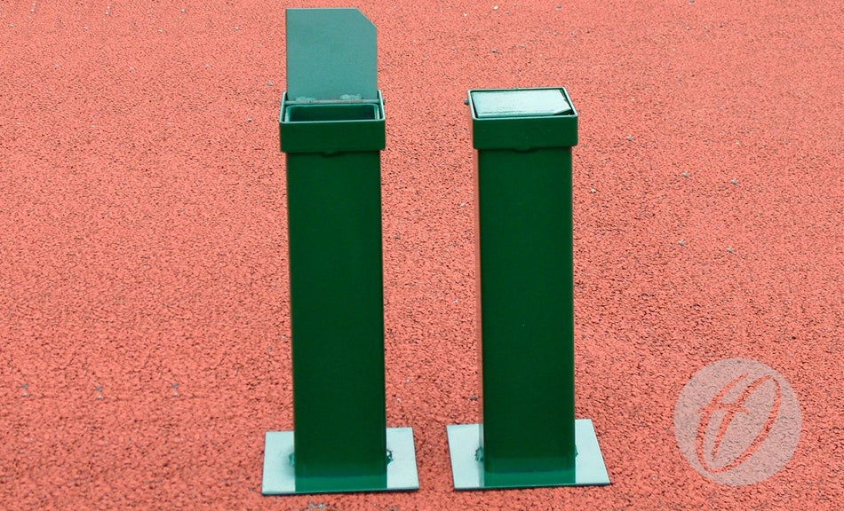 Two green metal outdoor ashtray bins stand on a textured red ground, each mounted on bases similar to Harrod Sport S8 Post Spare Sockets. One bin’s lid is open; the other is closed.