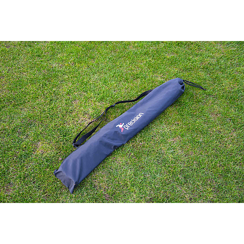 A blue bag rests on the grass, ideal for carrying the Precision Training Quick Setup Portable Rebounder (5ft x 3ft) with fast assembly and adjustable angle features.