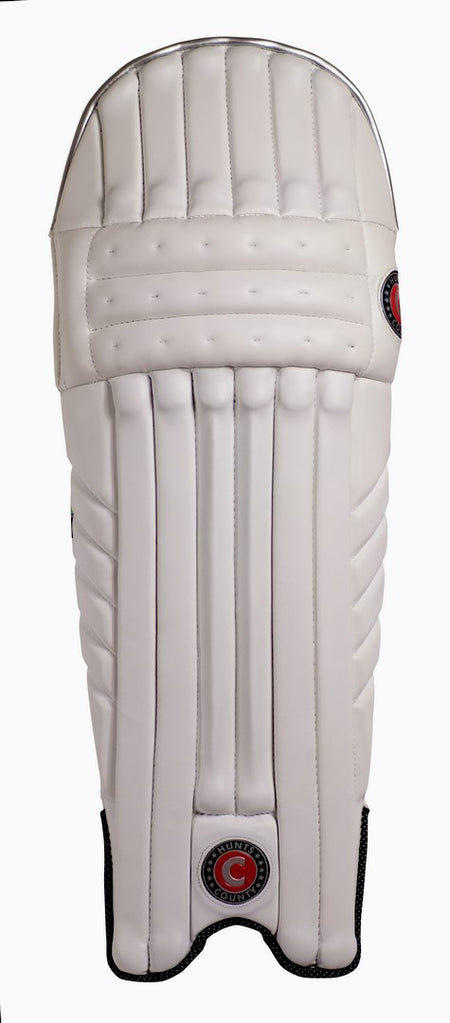 The Hunts County Tekton Senior Batting Pad is a single white leg guard with vertical padding and high-density foam, displaying two round red and black Hunts County logos, photographed against a plain white background.