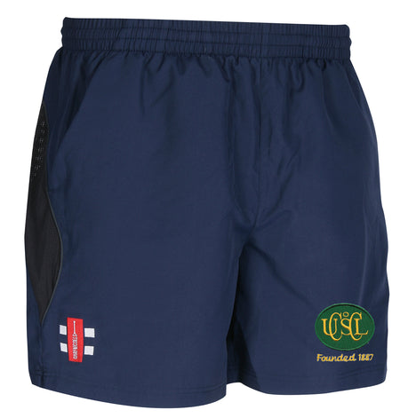 The Gray Nicolls Upton St Leonards CC Junior Training Shorts feature an elastic waistband, side mesh panels, a green and yellow "Founded 1827" logo, plus a red England cricket emblem—perfect for junior training or cricket.