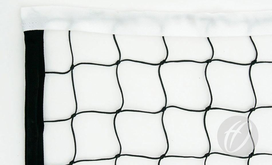 Close-up of the top corner of a Harrod Sport Supermatch Competition Volleyball Net, featuring black netting with white trim and evenly spaced squares, against a white background. A faint logo appears in the lower right corner.