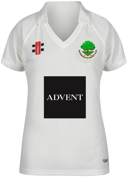 The Gray Nicolls Woodmancote CC Ladies Matrix V2 Short Sleeve Shirt is a breathable polyester cricket jersey in white, featuring a collar, club logo and text on the left chest, sponsor logos on the right, and a bold ADVENT logo in the center.