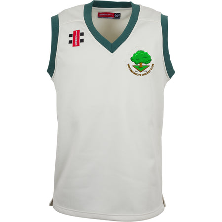 The Gray Nicolls Woodmancote CC Junior Pro Performance Slipover is a sleeveless white cricket jersey with green trim, featuring two embroidered chest logos: one rectangular in black/red and one circular with a green tree and yellow text.