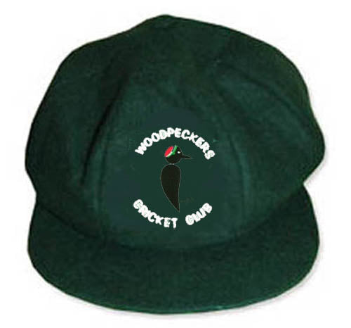 The Martin Berrill Sports Woodpeckers CC Baggy Cap is dark green and features an embroidered club logo with a central woodpecker and "WOODPECKERS CRICKET CLUB" elegantly curved around the bird.