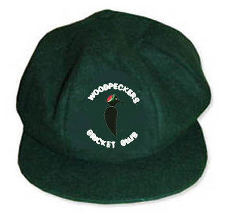 The Martin Berrill Sports Woodpeckers CC Baggy Cap is dark green and features an embroidered club logo with a central woodpecker and "WOODPECKERS CRICKET CLUB" elegantly curved around the bird.