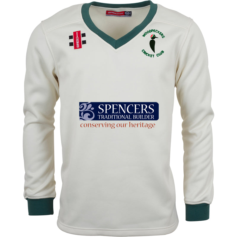 The Gray Nicolls Woodpeckers CC Pro Performance Sweater is a cream long-sleeve top with sport-specific fabric, green trim on collar and cuffs, the Woodpeckers Cricket Club logo, and sponsor logos on the chest.