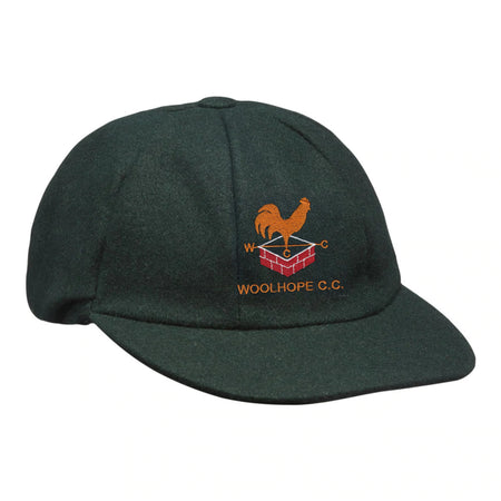 The Hunts County Woolhope CC Traditional Cap is a dark green cricket cap featuring the club's orange rooster on a red brick wall logo, with "W C C" and "WOOLHOPE C.C." embroidered below.