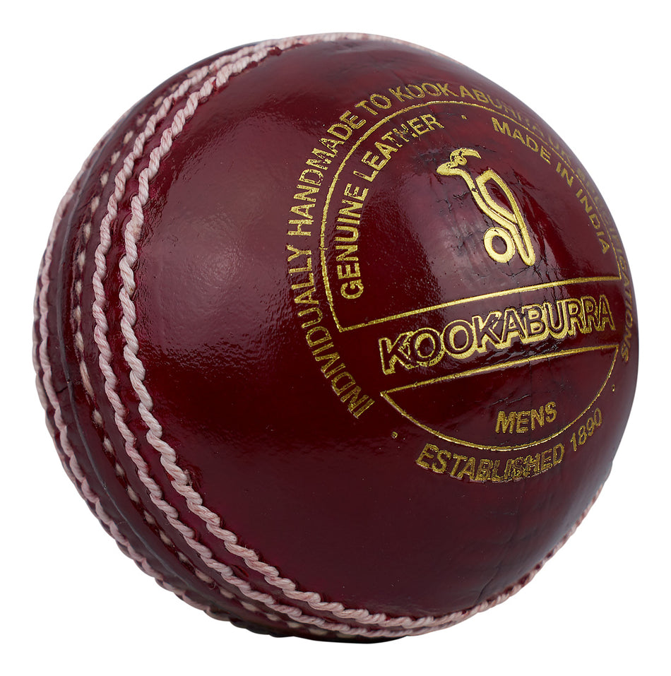 A close-up of the Kookaburra Supreme Crown Cricket Ball by Kookaburra, featuring red alum tanned leather, white stitching, gold lettering, and highlighting its hand-stitched quality and Indian craftsmanship.