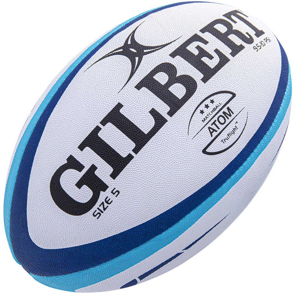 The Gilbert Atom Match Ball size 5 features blue and black accents on a white background with the bold GILBERT logo, making it a top choice for competitive play among quality Gilbert rugby balls.