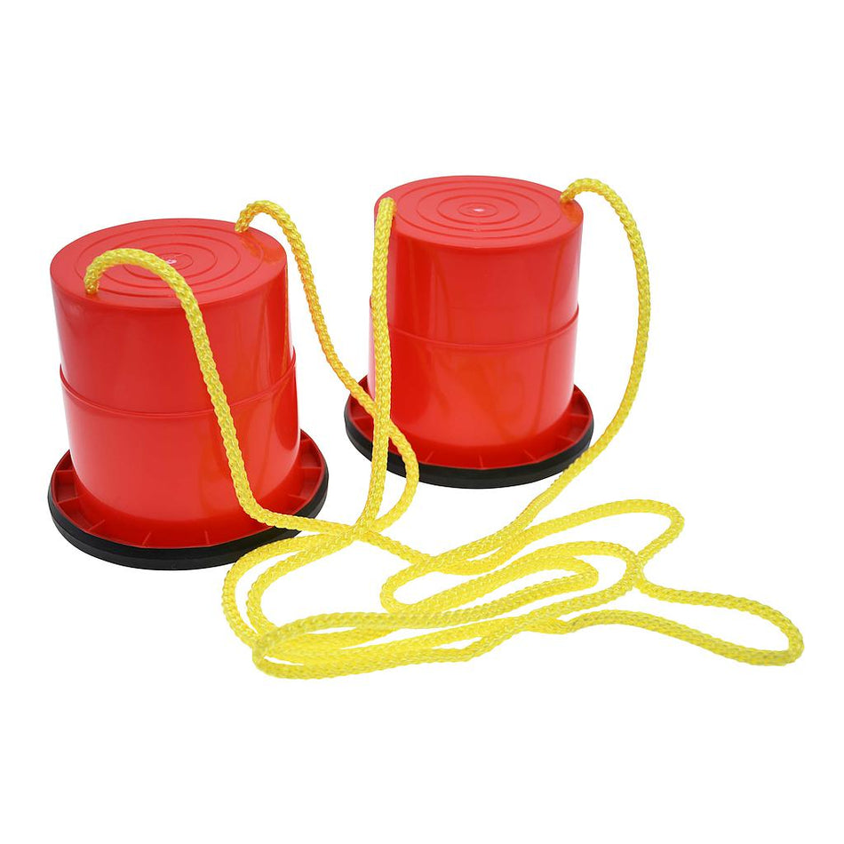 The Reydon Sports Essential Stilts are red plastic bucket stilts with black bases and yellow ropes, designed to help children develop balance and coordination through fun walking and play activities.