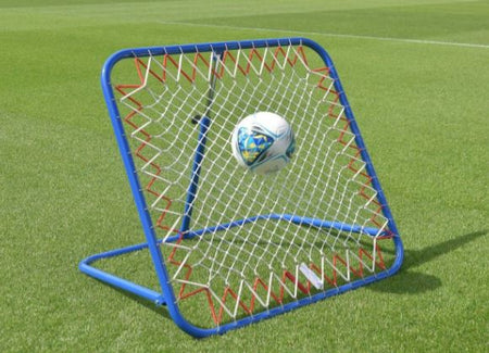 A soccer ball bounces off a Samba Sports Pro Rebounder, ideal for first touch drills, on a grassy field.