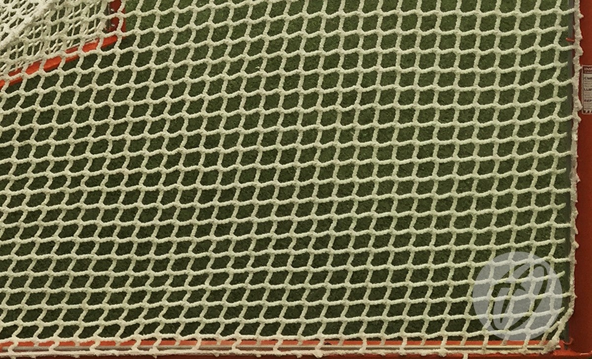 Close-up of a Harrod Sport Competition Lacrosse Nets 5MM in white, featuring heavy-duty knotless netting securely attached to a red metal frame, with green artificial turf visible in the background.