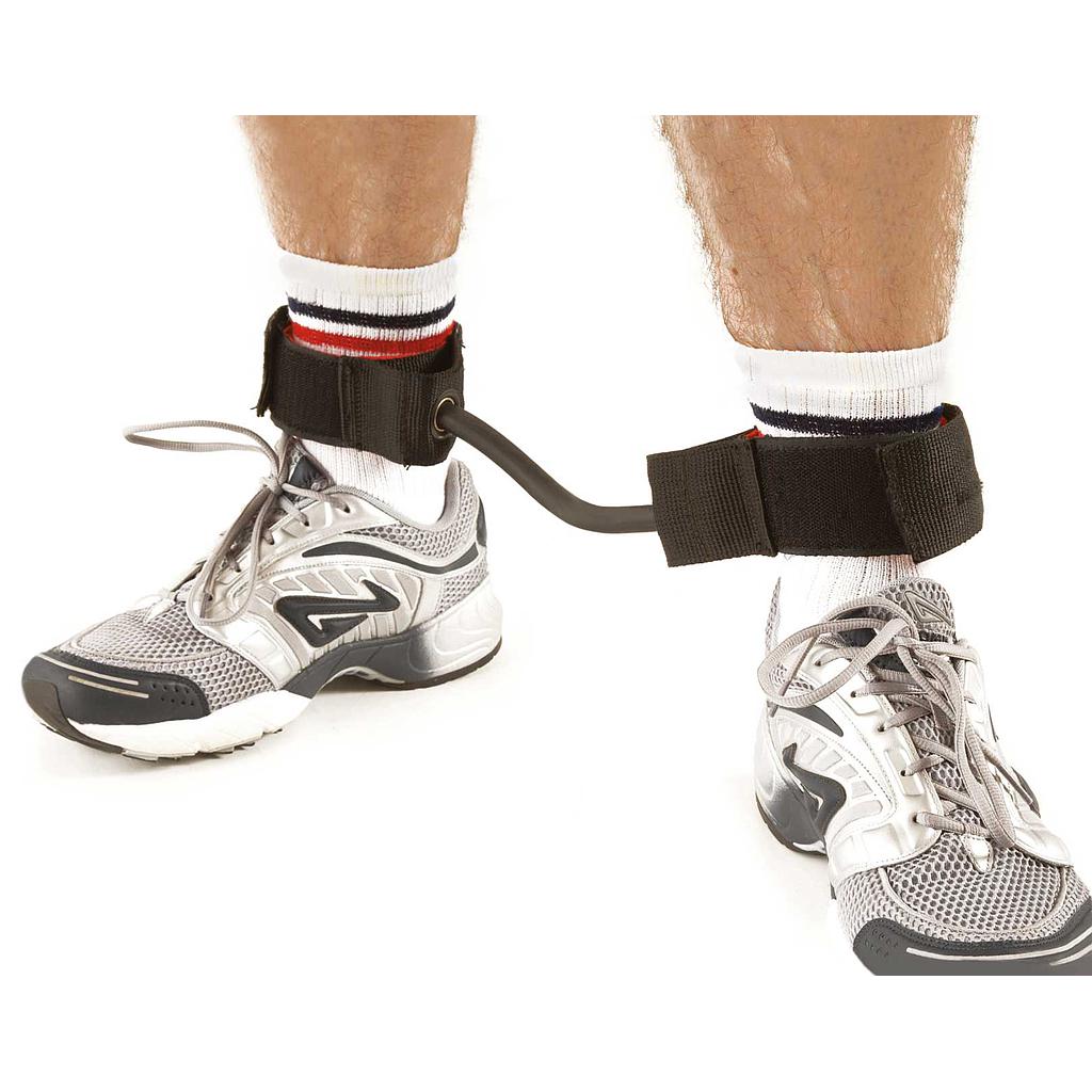 A close-up shows a person’s lower legs wearing athletic shoes and socks, with the Precision Training Precision Leg Toner’s padded ankle collars fastened together to restrict leg movement for targeted training.