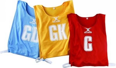 The Gilbert Netball Bibs set includes three breathable polyester bibs in blue, yellow, and red, each labeled GD, GK, and C with white lettering and the Gilbert logo—perfect for your team.