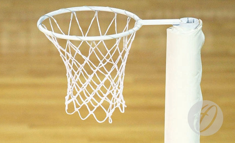 A close-up of the Harrod Sport International Netball Rings & Nets, featuring a 16mm steel ring and white polyethylene net on a padded pole, set against a blurred wooden court background.