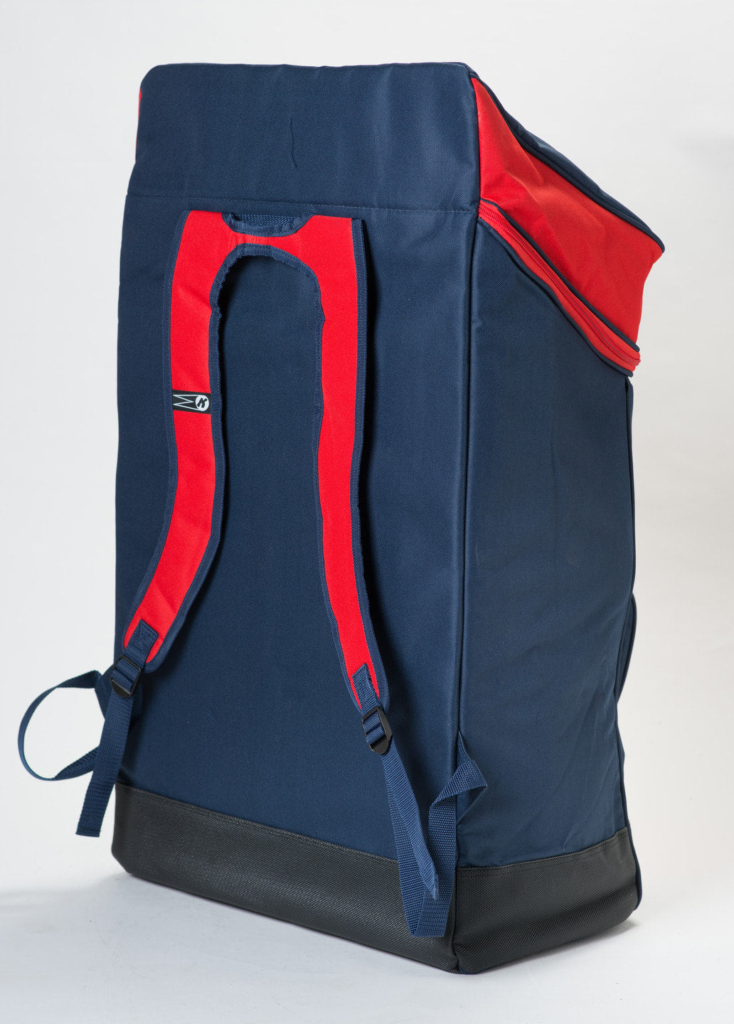 The Katchet KoachSak Duffle is a large navy blue backpack with red shoulder straps, rucksack handles, a black base, and a zippered red top flap. Photographed on a white background. Water resistant for added durability.