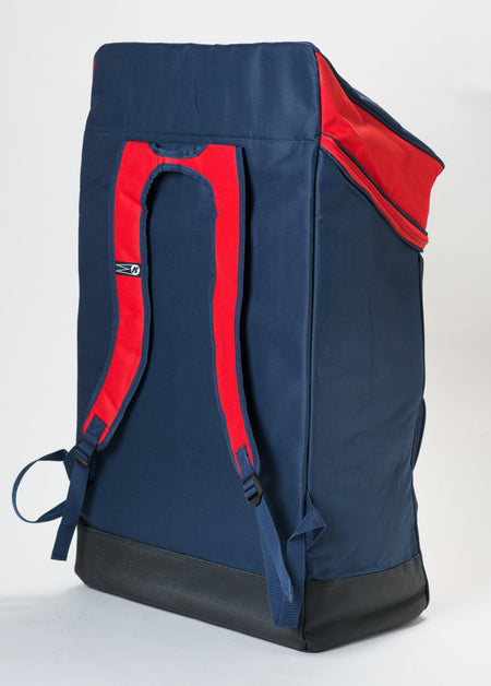 The Katchet KoachSak Duffle is a large navy blue backpack with red shoulder straps, rucksack handles, a black base, and a zippered red top flap. Photographed on a white background. Water resistant for added durability.