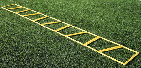 The Precision Training Precision Poly Grid System (set of 10) in yellow lies flat on green artificial grass, ideal for agility training and footwork drills.
