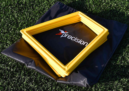A stack of yellow Precision Training Poly Grid System markers (set of 10) rests on a black branded carrying bag, placed atop green artificial turf.