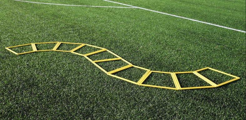 The Precision Training Precision Poly Grid System (set of 10), perfect for footwork drills, is arranged in a wavy pattern on green artificial turf with white field lines visible in the background.