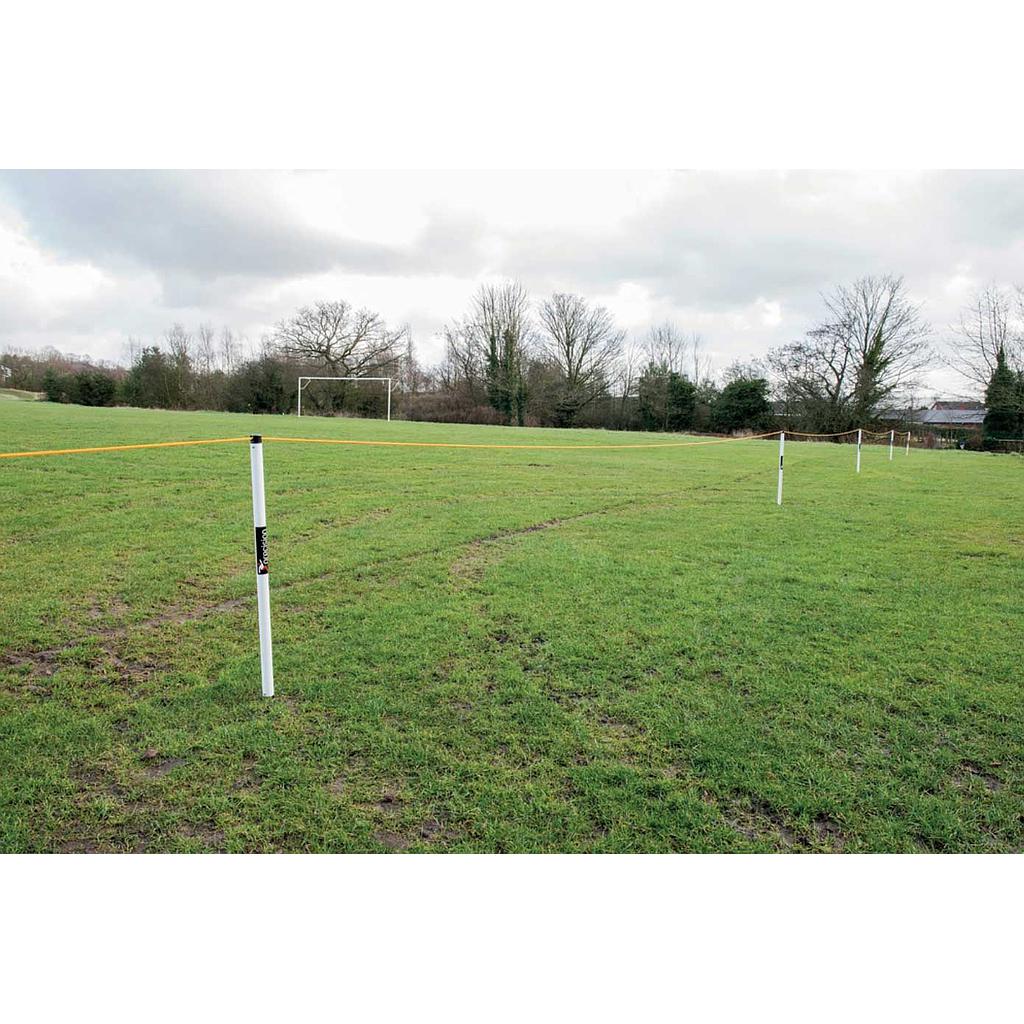 A grassy sports field with a soccer goal, bordered by Precision Training’s Precision Crowd Barrier—white posts and yellow tape—beneath cloudy skies, with a nearby tent and trees framing the scene.