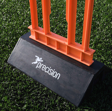 A close-up of a Precision Training Pro HX Mannequin in orange on artificial grass, with a black base showing the Precision Training logo—ideal for football free kick training.