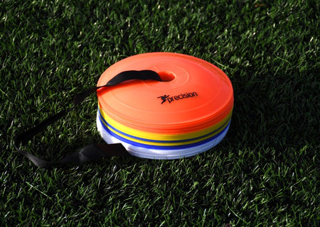 A stack of Precision Pro Near Flat Markers by Precision Training with a black strap rests on green artificial grass. The orange top marker is ideal for soccer training. Set includes 40 colorful low profile cones.