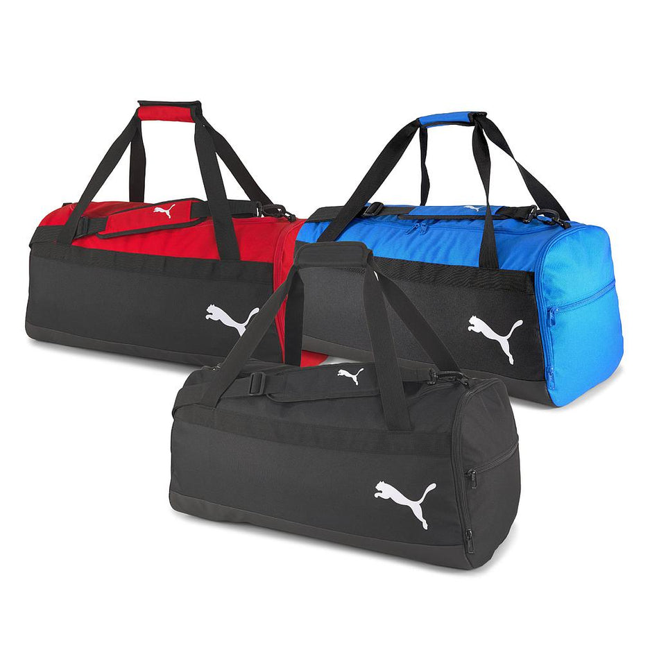 Three large Puma Team Goal 23 teambags in black, red, and blue are shown side by side. Each bag has dual handles, a shoulder strap, and features the white Puma logo—ideal for carrying your sports gear.