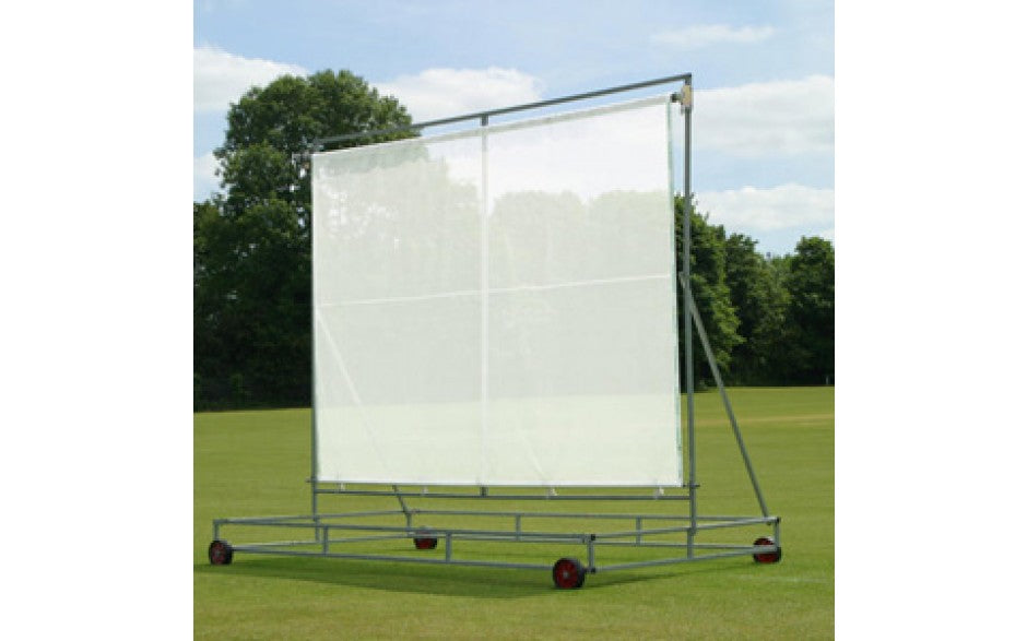 A Retrax Replacement Roller Sight Screen (Material Only) by Martin Berrill Sports is shown as a white panel on a metal frame with red wheels, set on grass with trees and a partly cloudy sky in the background.
