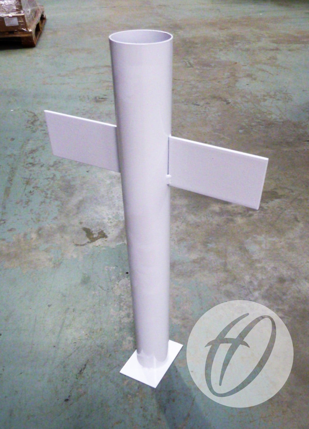 A white metal signpost resembling the Harrod Sport Rugby Post Spare No. 2A Socket, with a vertical cylinder and two horizontal arms, stands on a square base atop a green floor. A circular logo featuring a stylized “H” is positioned in the bottom right corner.