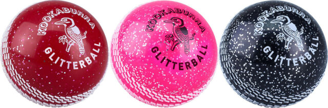 Three Kookaburra Glitter balls—red, pink, and black—are displayed side by side, each featuring white speckles and the Kookaburra logo on a soft plastic surface.