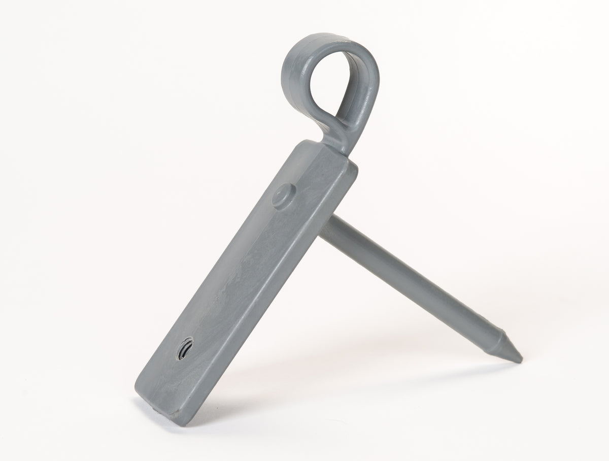The Fusion Multi-stump Spike by Fusion, featuring a gray plastic rectangular body with a circular loop at one end and mounted on a pointed fibreglass spike, is displayed against a white background.