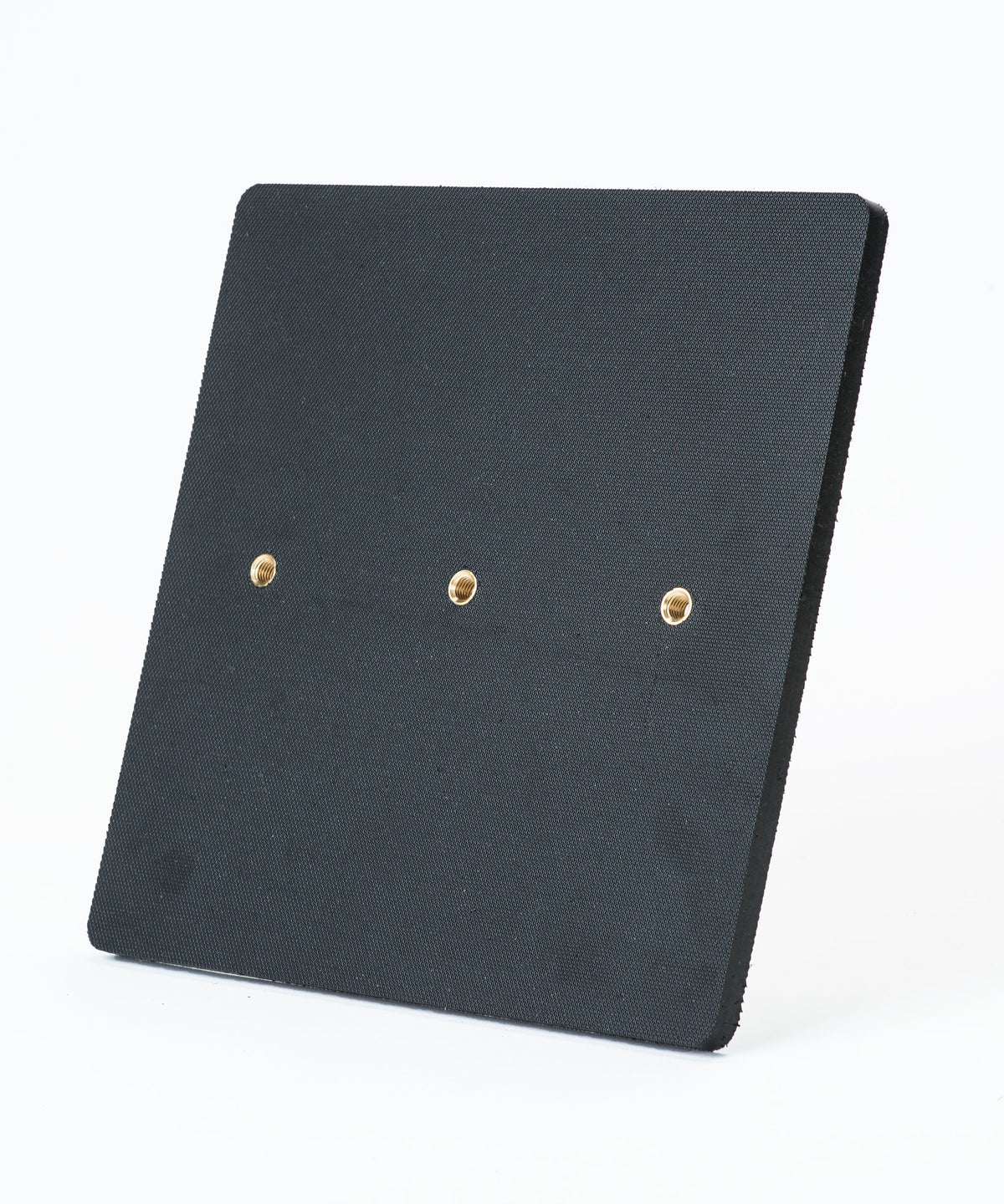 The Fusion Multi-Stump All Weather Base by Fusion is a square black textured panel with three evenly spaced brass-colored holes in a horizontal row, shown on a plain white background. It’s ideal for hard wicket cricket and built for all-weather use.