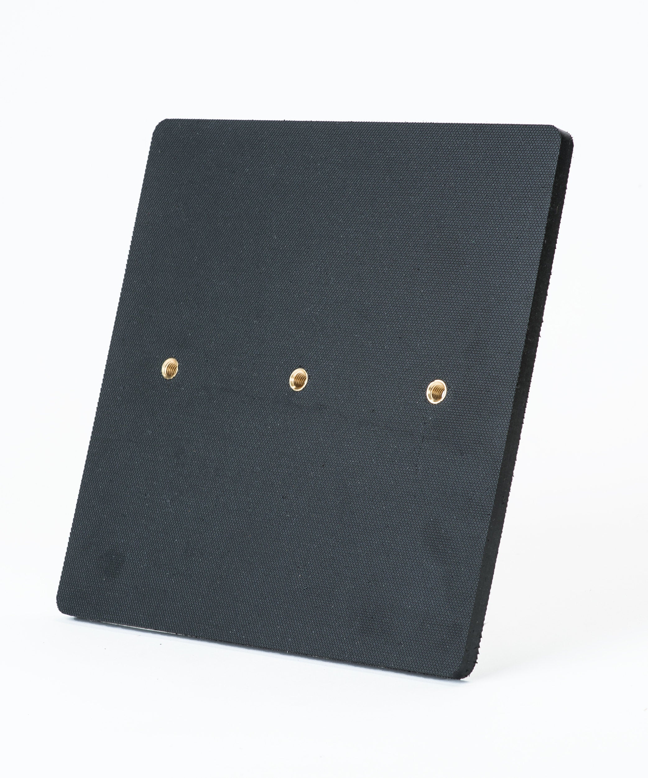 The Fusion Multi-Stump All Weather Base by Fusion is a square black textured panel with three evenly spaced brass-colored holes in a horizontal row, shown on a plain white background. It’s ideal for hard wicket cricket and built for all-weather use.