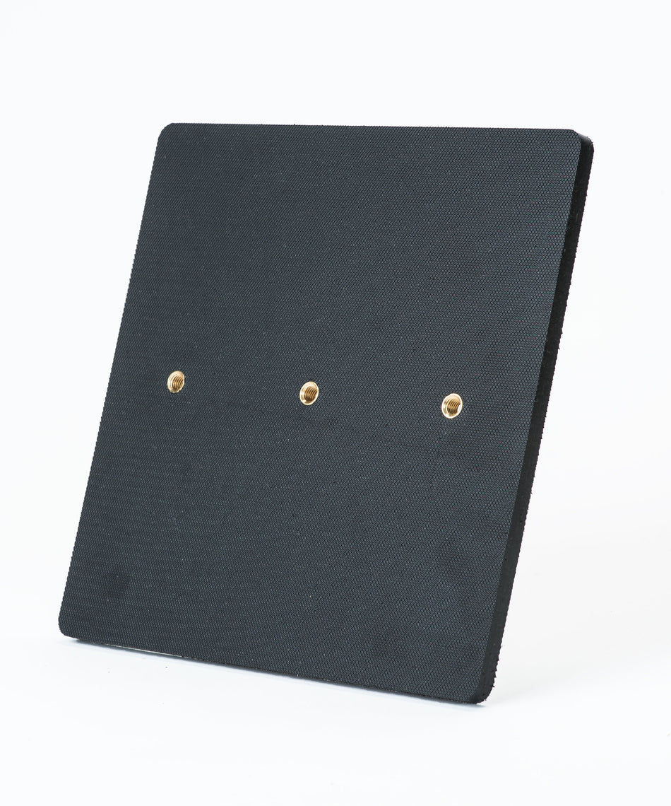 The Fusion Multi-Stump All Weather Base by Fusion is a square black textured panel with three evenly spaced brass-colored holes in a horizontal row, shown on a plain white background. It’s ideal for hard wicket cricket and built for all-weather use.