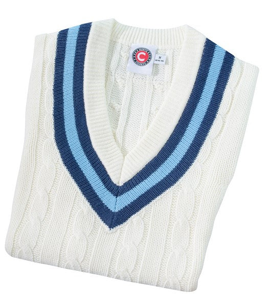 The Hunts County Trimmed Cricket Sweater is a folded white acrylic vest with a deep V-neck and dark blue and light blue striped trim. Size label and circular logo tag appear inside the collar.