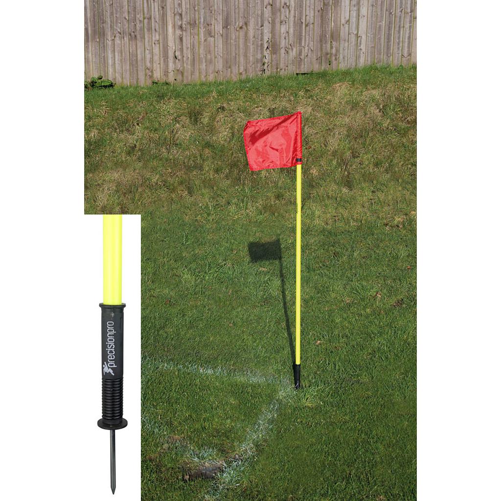 A set of four Precision "Sprung" Corner Posts by Precision Training in fluorescent yellow stands at the corner of a grassy soccer field; an inset highlights the durable, weatherproof black spiked base.