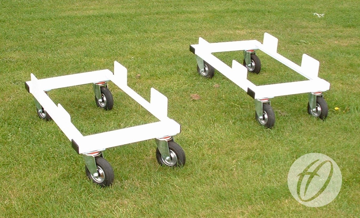 Two white Harrod Sport 3G Euro Portagoal Transporter Trolleys with four wheels and upturned steel edges are on green grass. Each trolley displays a circular logo in the corner. Supplied as a set of four.