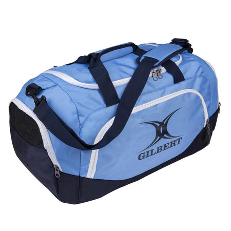 The Gilbert V3 Club Player Holdall by Gilbert comes in Navy/Sky with black handles, an adjustable shoulder strap, and white zippers. The GILBERT logo is on the side pocket—perfect as a rugby holdall for all your gear.