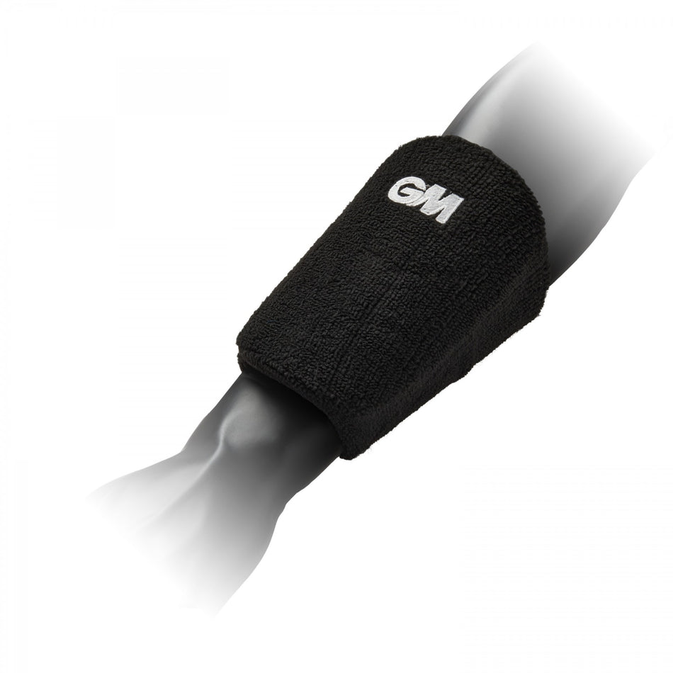 The Gunn & Moore Players Wrist Guard, a black sports arm guard with a white GM logo, features high impact material and shock absorbing foam for professional protection. Shown worn on a mannequin’s forearm against a plain white background.